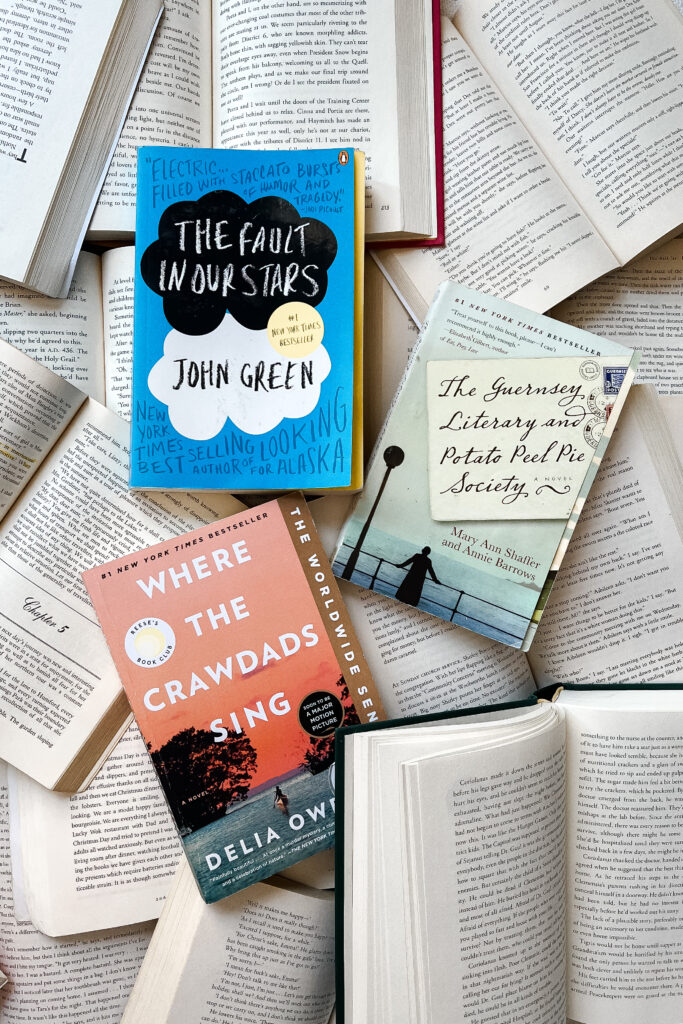 book flatlay of the fault in our stars, the guernsey literary and potato peel pie society, and where the crawdads sing. 