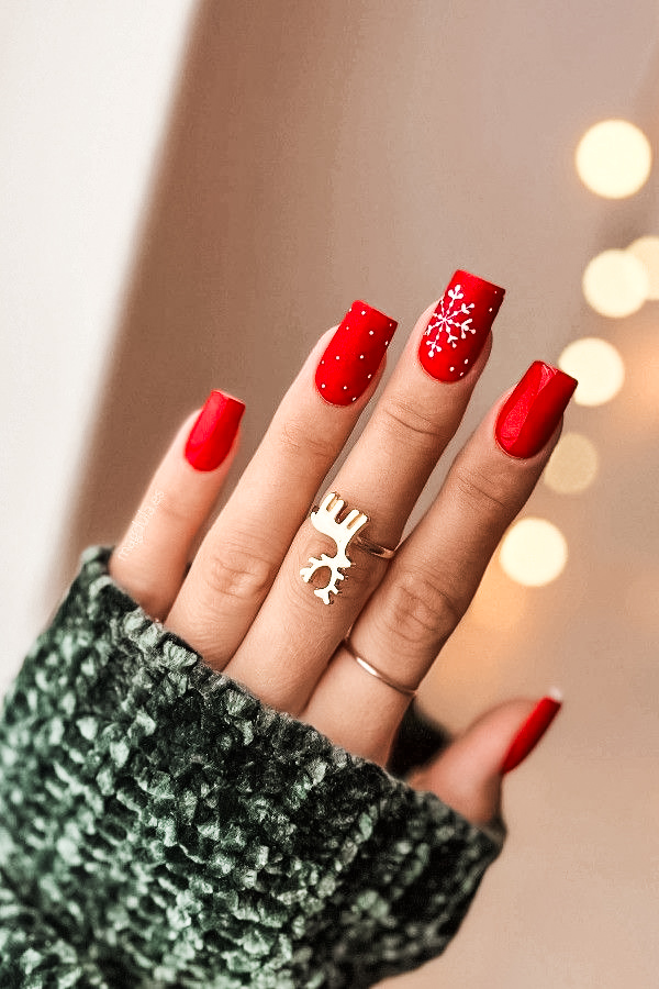 womans hand with red nail polish in winter