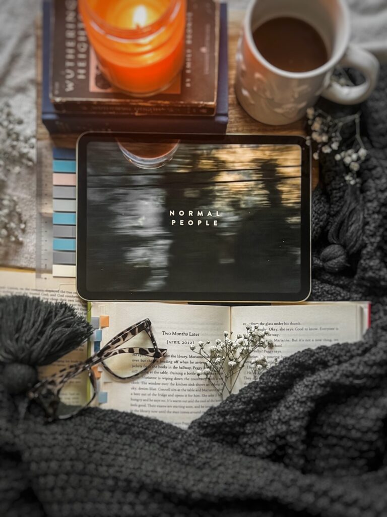 flatlay picture of Sally Rooney's Normal people book with the Hulu adaptation playing