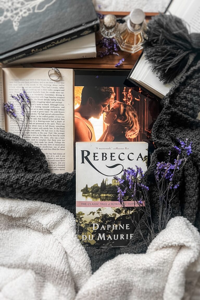 Flatlay featuring a copy of Rebecca by Daphne du Maurier alongside an iPad displaying a scene from the 2020 film adaptation