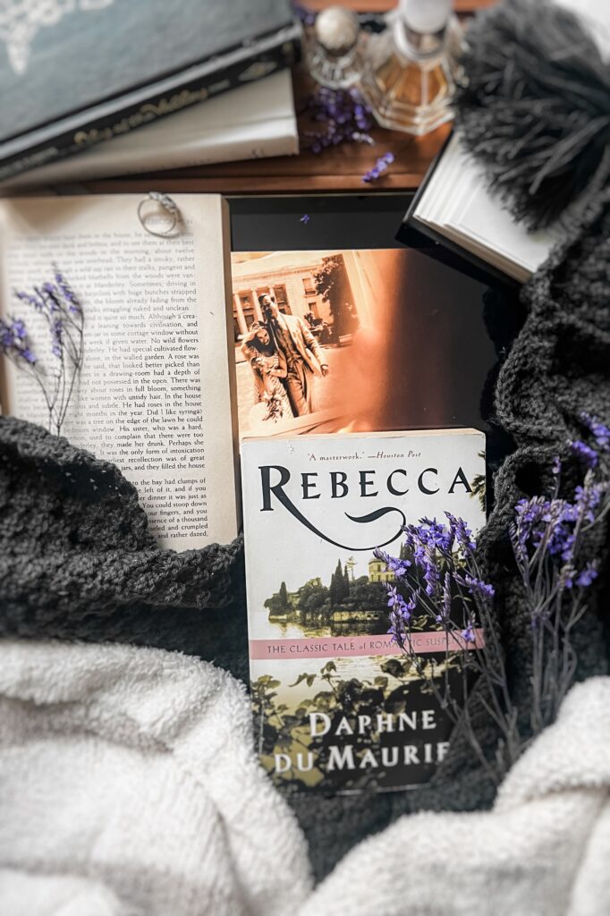 Flatlay featuring a copy of Rebecca by Daphne du Maurier alongside an iPad displaying a scene from the 2020 film adaptation