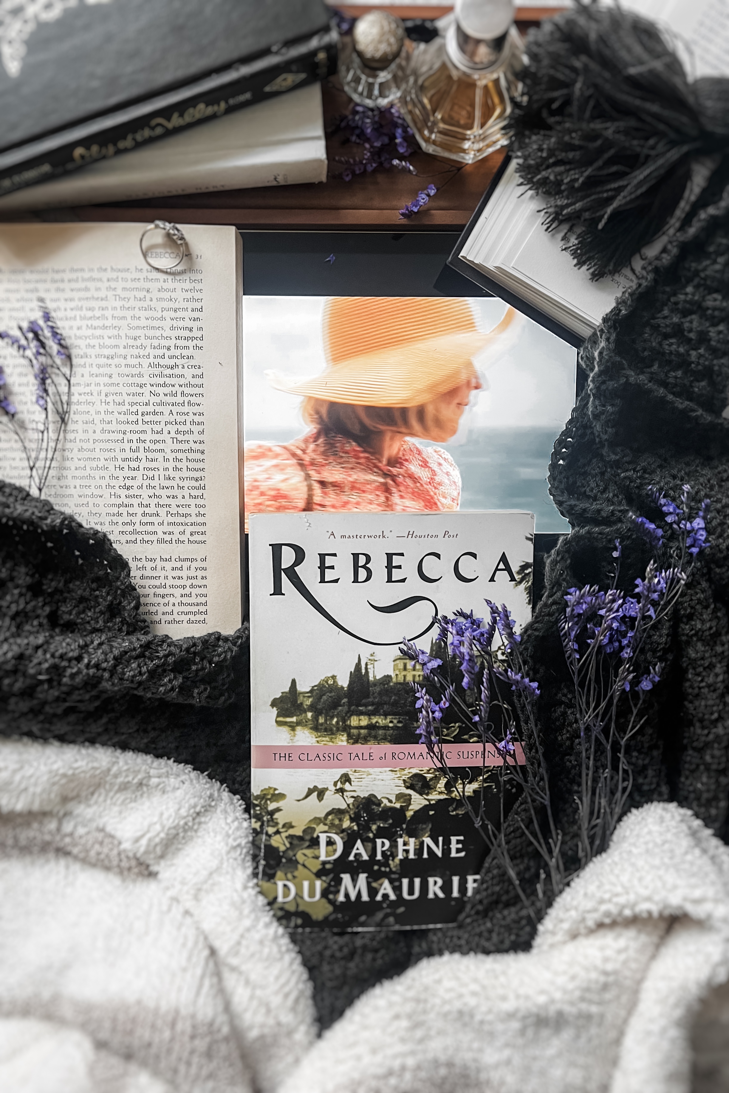 Flatlay featuring a copy of Rebecca by Daphne du Maurier alongside an iPad displaying a scene from the 2020 film adaptation