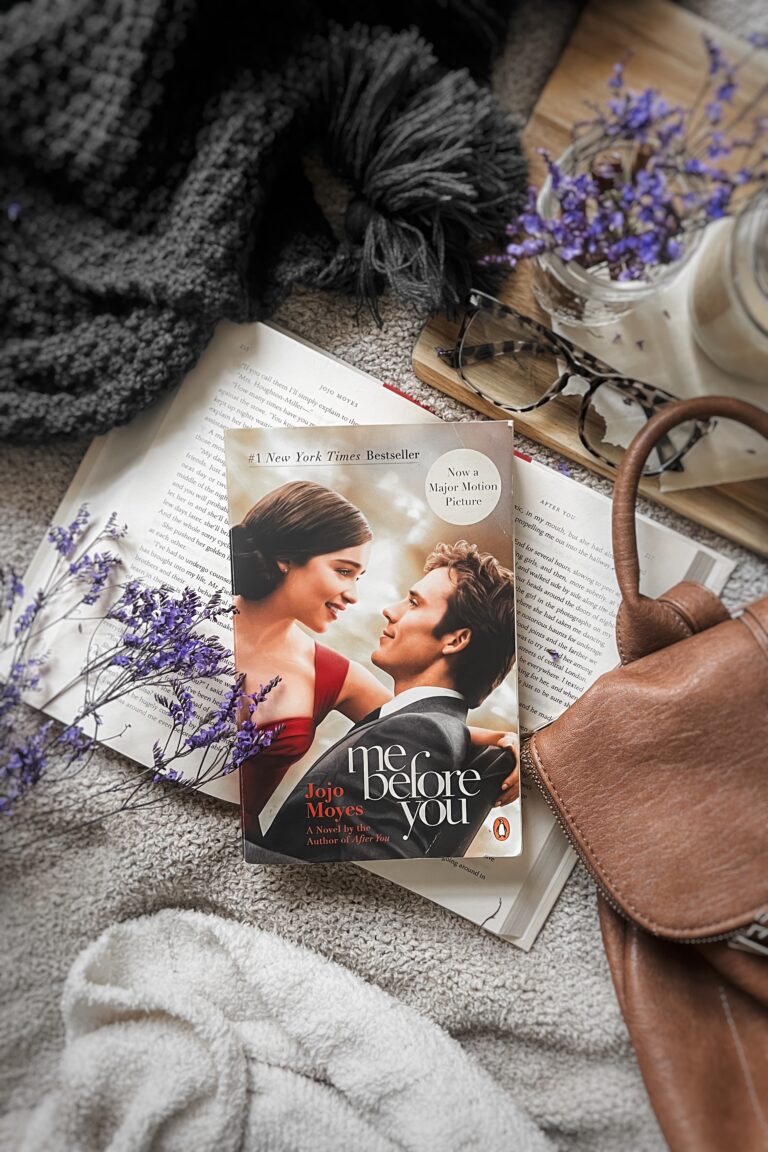 A thrifted copy of Me Before You by Jojo Moyes, a perfect romantic read for Valentine’s Day, placed on a cozy blanbket with soft lighting.